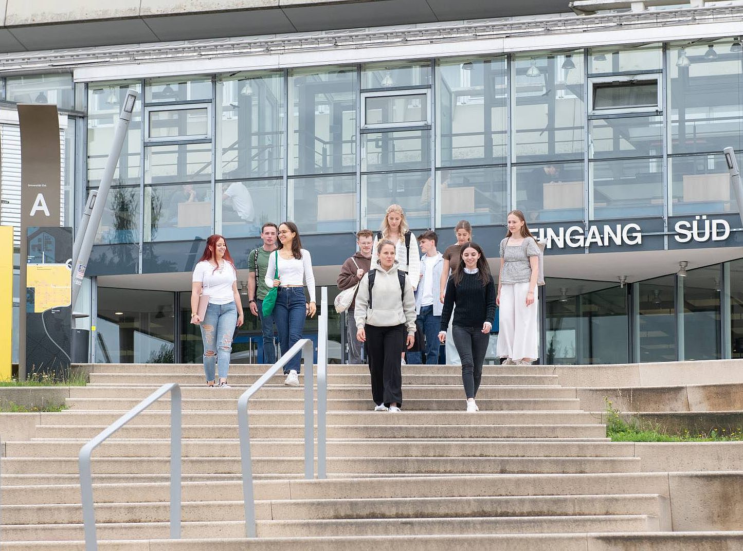Eingang Süd_Treppenlauf Studierende laufen den Treppenstieg am Eingang Süd der Universität hinunter.